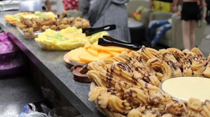 Buffet of churros, fruits, and other foods at El Centro event